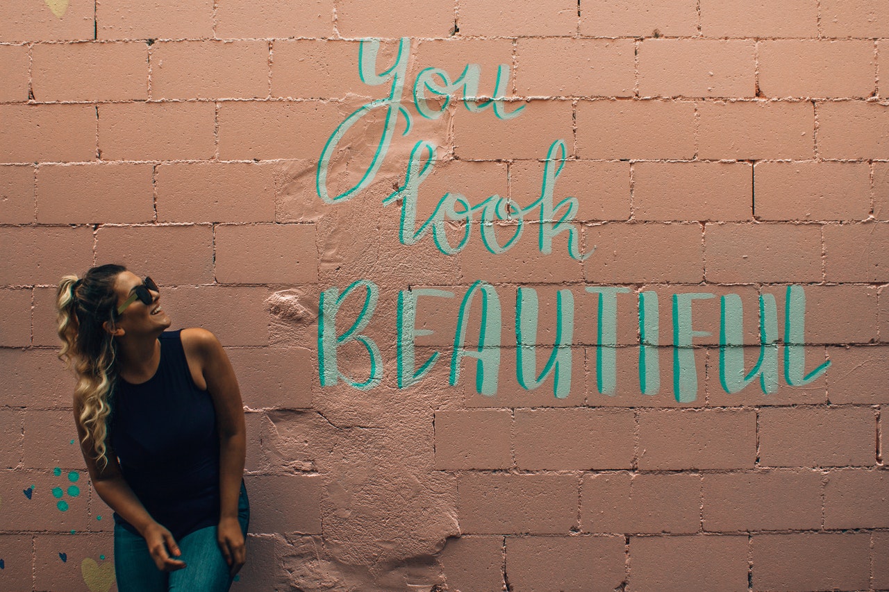 a woman looking at a sign on the wall